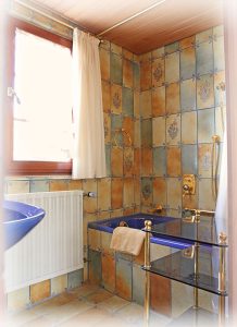 Das Tageslichtbad verfügt über eine Badewanne und ein Waschbecken mit Spiegel.